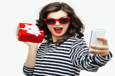 Girl Holding Gift Taking A Selfie Front Cover Holiday Gift Ideas in Lancaster for the Whole Family